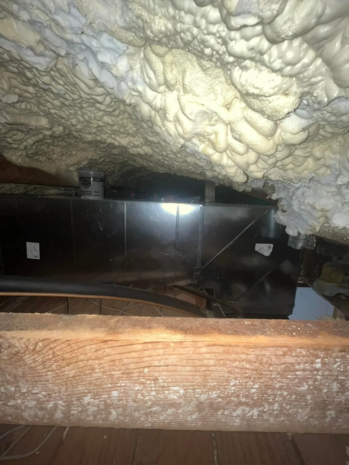 Attic air handler with proper insulation and ventilation installation showing professional HVAC work