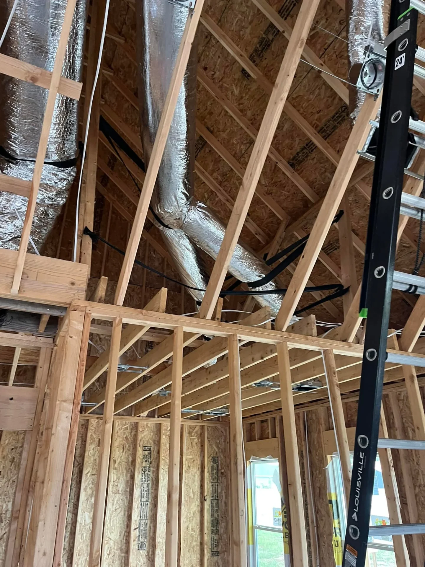 New construction HVAC ductwork installation showing proper routing and register placement in framed walls